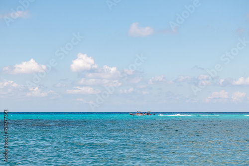 łódź motorową z turystami na pięknym lazurowym spokojnym morzu photo