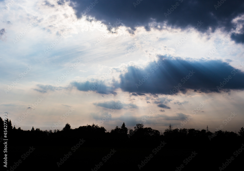 The rays of God in the river landscape. The sun's rays shine through the clouds over the water surface and the shore. Copy space The rays of God in the river landscape. The sun's rays shine through the clouds over the water surface and the shore. Copy space