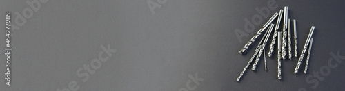 Drills for metal lie on a black paper background. Hole processing tool