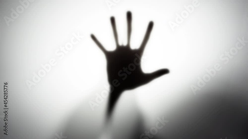 4k video of a silhouette of a man's hands behind a translucent glass. The concept of the other world, victims of violence, paronormal, ghosts.
