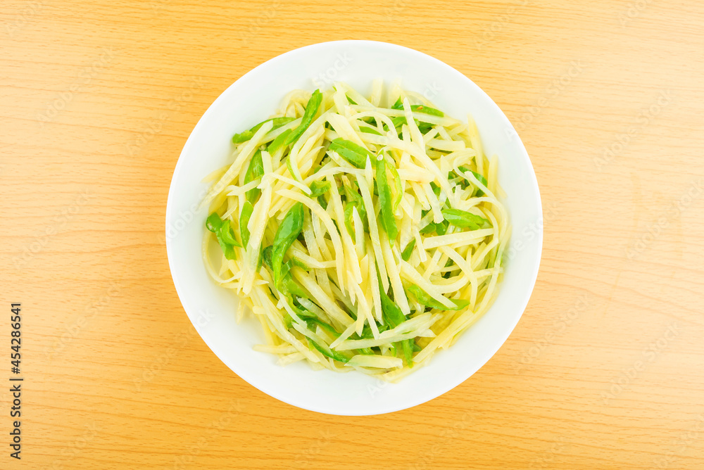 A dish of homemade green pepper and potato shreds on the table A dish of homemade green pepper and potato shreds on the table