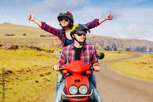 Fototapeta Naklejka Na Ścianę i Meble -  Happy Couple riding a motorbike. Young hipster riders enjoying the trip. Adventure and vacations concept