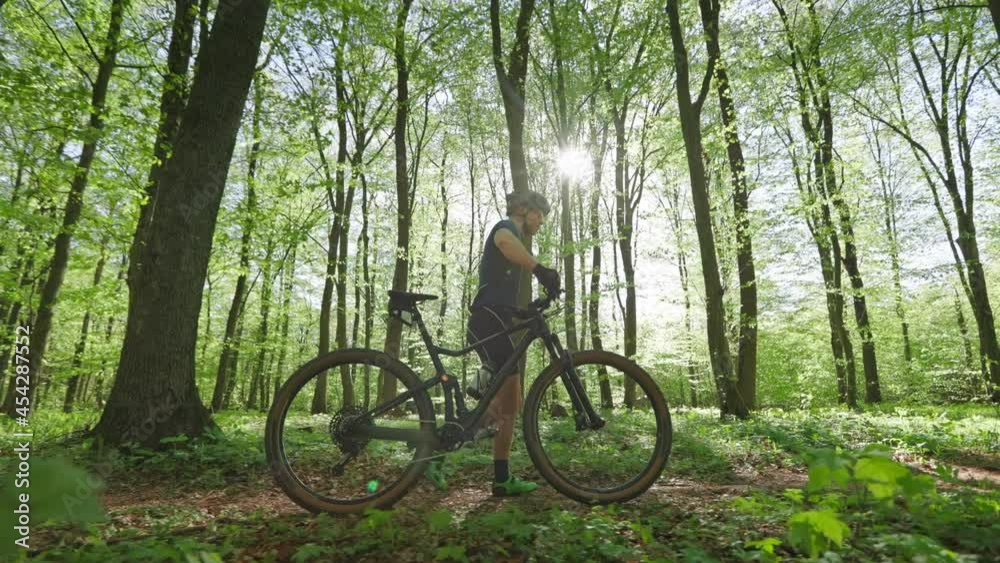 The cyclist is walking next to the bike. He is wearing cycling gear. The camera is moving with him. 4K The cyclist is walking next to the bike. He is wearing cycling gear. The camera is moving with him. 4K