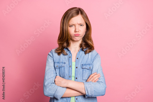 Photo of young attractive girl folded hands unhappy upset sad offended isolated over pink color background photo