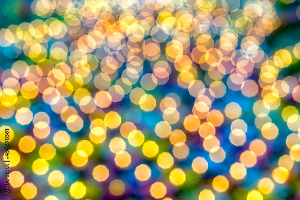 Golden circular blur light bokeh abstract on a blurred blue background. Holiday concept backdrop with twinkling bright shapes.Blinking Christmas