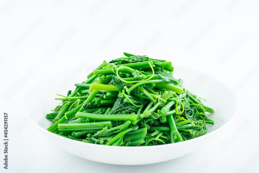 A dish of fried pumpkin vines on white background A dish of fried pumpkin vines on white background