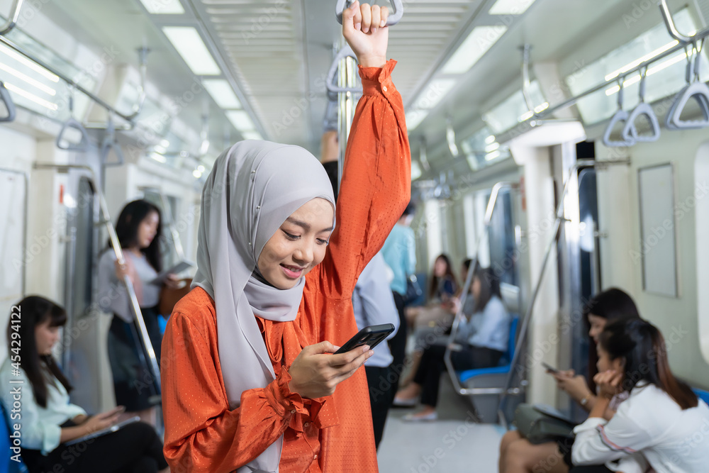 Asian muslim woman wear hijab head scarf in the metro or train subway, public transport