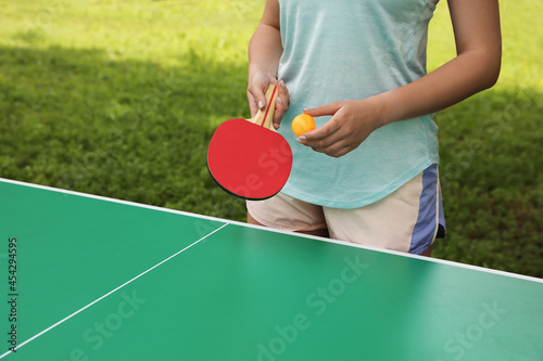 Young woman playing ping pong in park, closeup