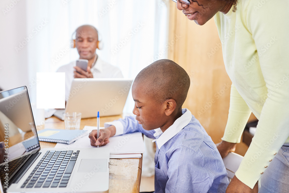 Schüler beim Homeschooling am Computer im Wohnzimmer Schüler beim Homeschooling am Computer im Wohnzimmer