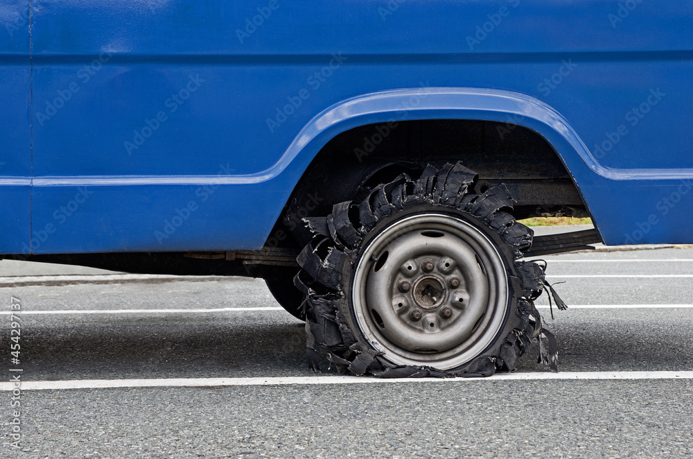 Close up of destroyed blown out tire with exploded and damaged rubber. Flat tyre. Tyre explosion on the road. Close up of destroyed blown out tire with exploded and damaged rubber. Flat tyre. Tyre explosion on the road.