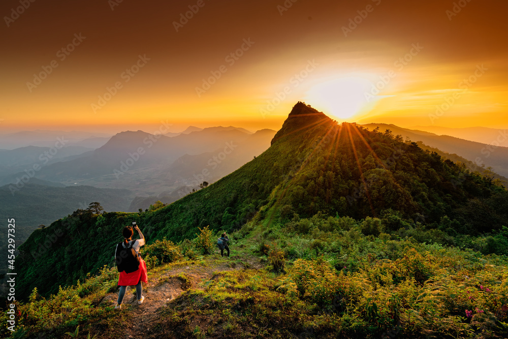 Woman with backpack from behind and beautiful Landscape of mountain with sunset in Chiang Rai, Thailand