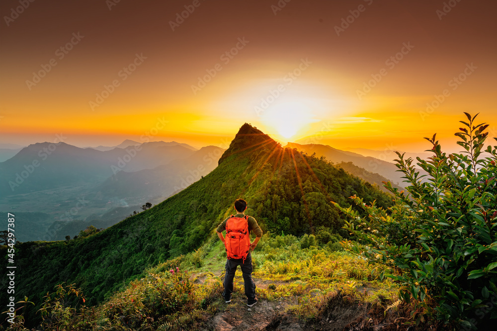 Traveler with backpack from behind and beautiful Landscape of mountain with sunset in Chiang Rai, Thailand