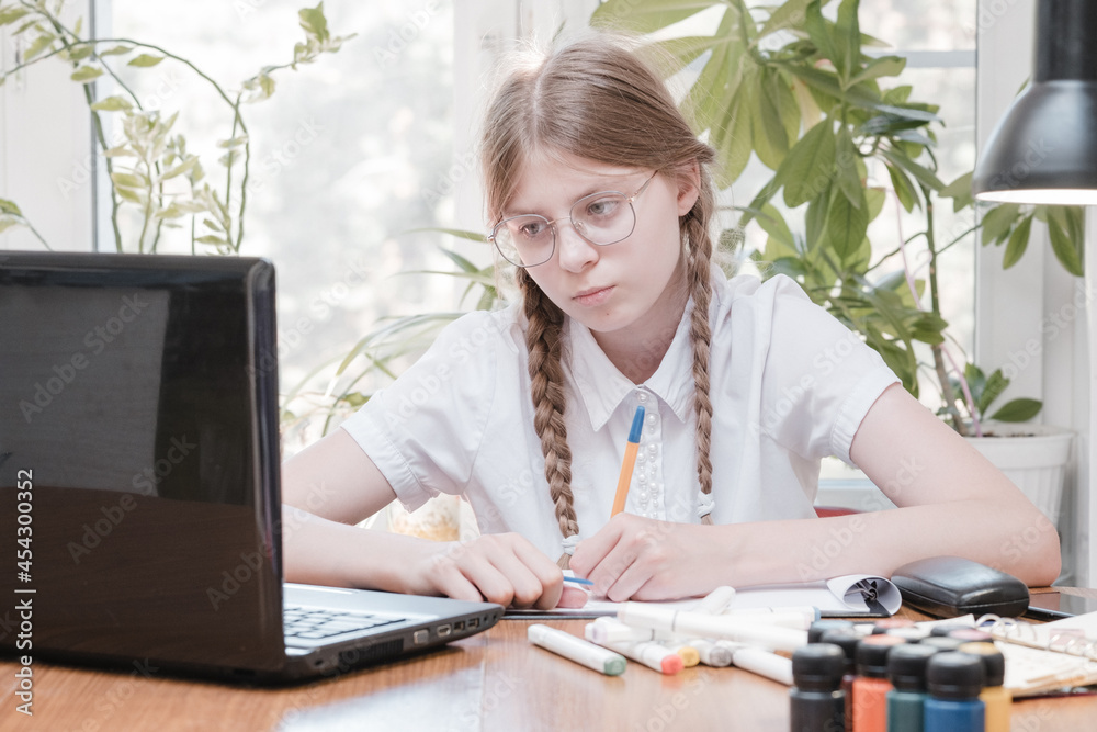 Schoolgirl self isolation using laptop for his homework. Girl doing using digital tablet searching information on internet during covid 19 lock down. Social distance, E-learning online education Schoolgirl self isolation using laptop for his homework. Girl doing using digital tablet searching information on internet during covid 19 lock down. Social distance, E-learning online education