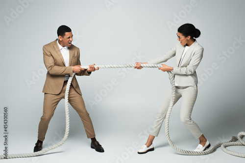 Canvas-taulu businessman and businesswoman pulling rope on grey, gender equality concept