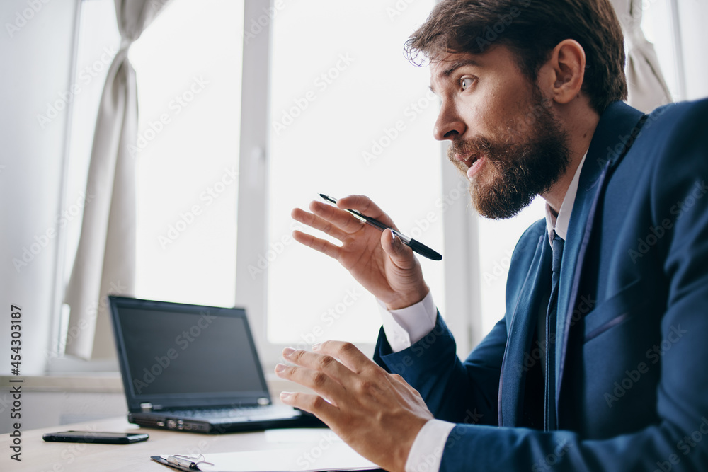 manager sitting at a desk in front of a laptop finance professional manager sitting at a desk in front of a laptop finance professional