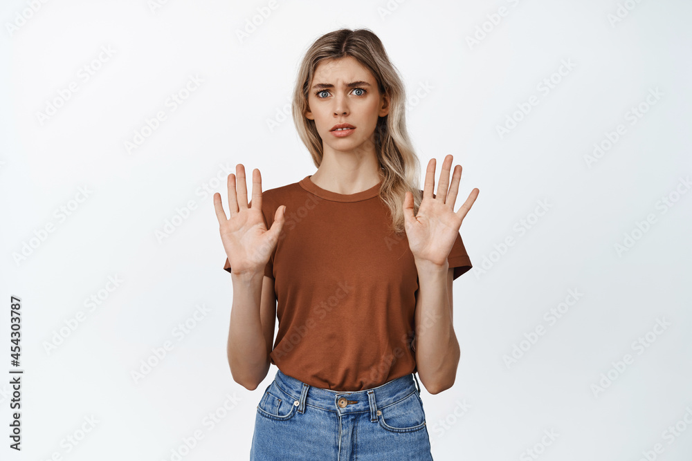 Young freak out woman raising empty hands, refusing something, rejecting offer and saying no, standing in t-shirt and jeans over white background Young freak out woman raising empty hands, refusing something, rejecting offer and saying no, standing in t-shirt and jeans over white background