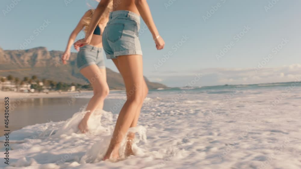 teenage girls on beach splashing in sea water having fun best friends enjoying warm summer day on vacation teenage girls on beach splashing in sea water having fun best friends enjoying warm summer day on vacation