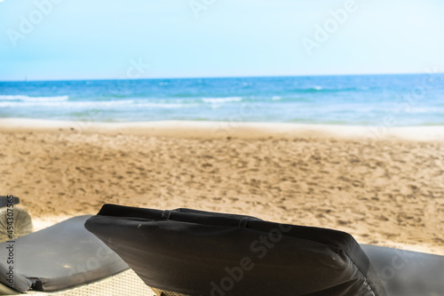 empty beach chair at sand and blue sea in tropical scene