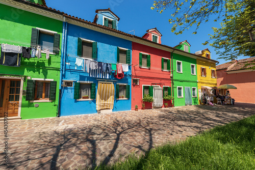 Burano island, bright row houses with clothes hanging on clotheslines to dry in the sun. Venetian lagoon, Venice, UNESCO world heritage site, Veneto, Italy, Europe.