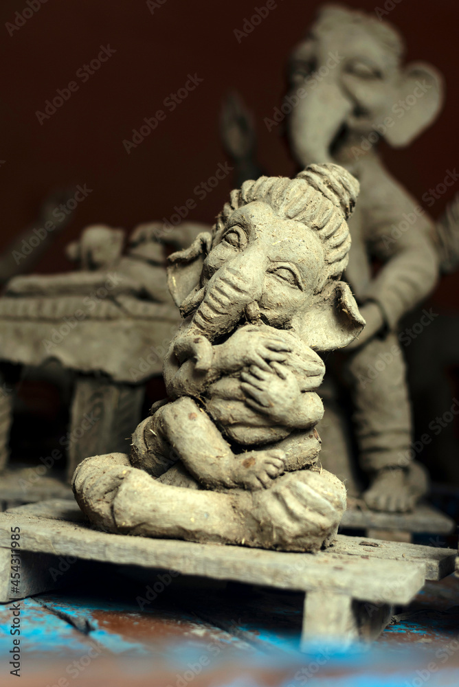 Closeup of unfinished clay model of Lord Ganesh\Ganesha holding modak, his favorite sweet 