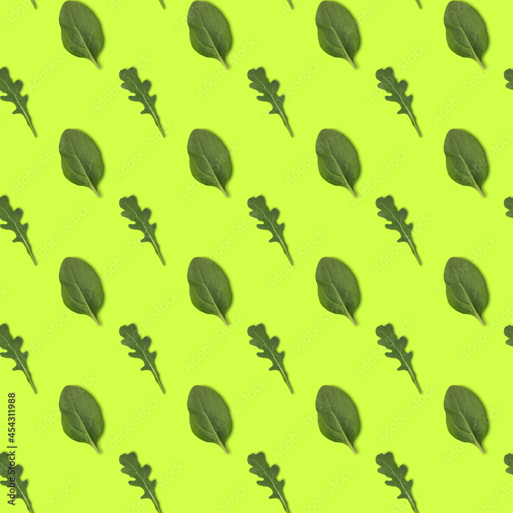 Seamless pattern with green arugula ans spinach isolated on yellow background, top view Seamless pattern with green arugula ans spinach isolated on yellow background, top view