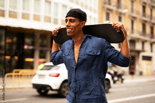 African man with skateboard. Young handsome man having fun outdoors.