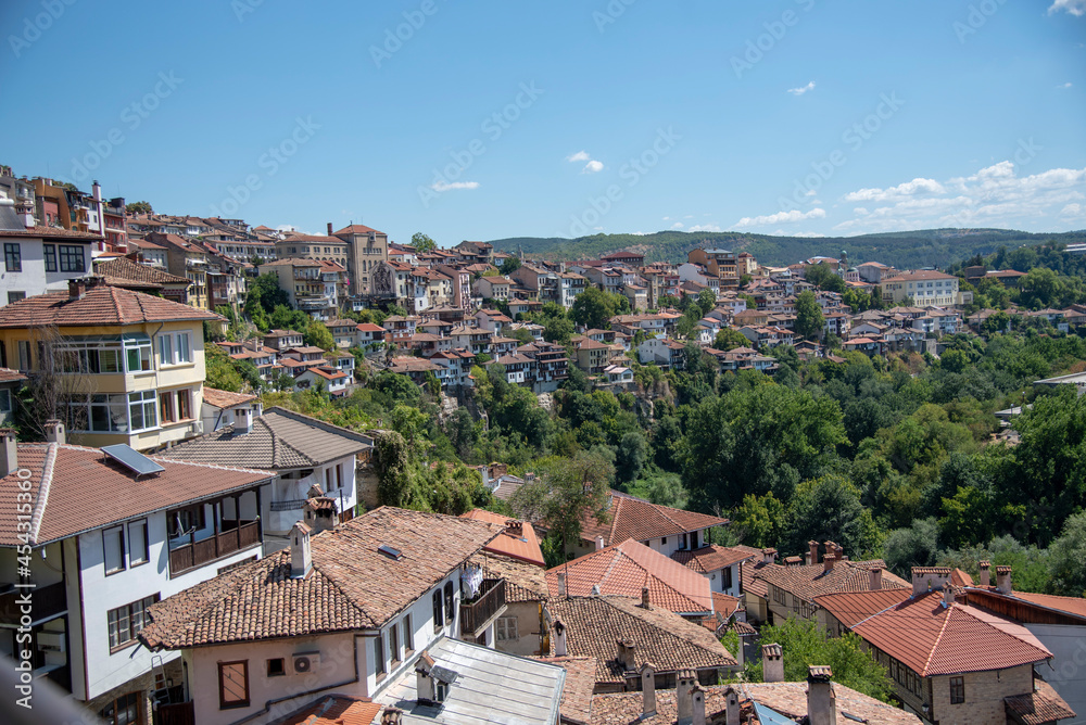 Houses with red tiled roofs , built on a mountain under a bright blue sky.Veliko Tarnovo in a beautiful summer day, Bulgaria