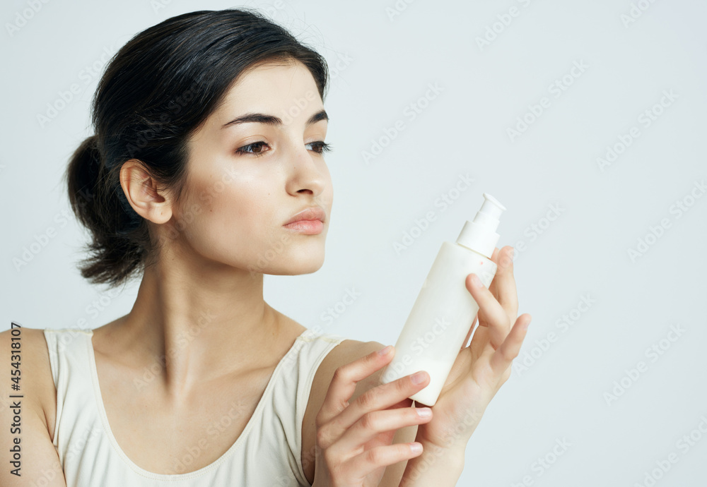 brunette in white tank top cream jar moisturizing health care brunette in white tank top cream jar moisturizing health care