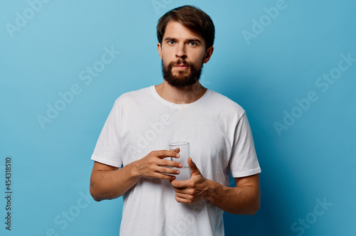 bearded man drinking water blue background
