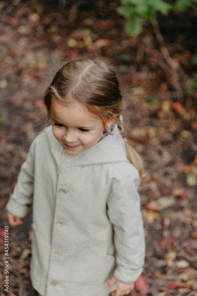 girl dressed in stylish autumn clothes posing for a photo on a walk in the park