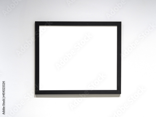 Photo frame mockup  black frame with white blank sheet on the wall. Space for text.