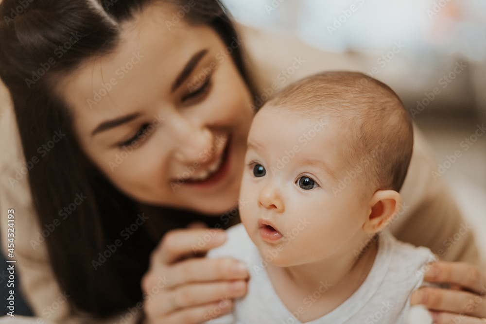 beautiful active baby lying in the crib and looking at the camera, soft clean skin, cute look and happy face of the newborn baby in the bedroom. Beautiful background for children's themes beautiful active baby lying in the crib and looking at the camera, soft clean skin, cute look and happy face of the newborn baby in the bedroom. Beautiful background for children's themes