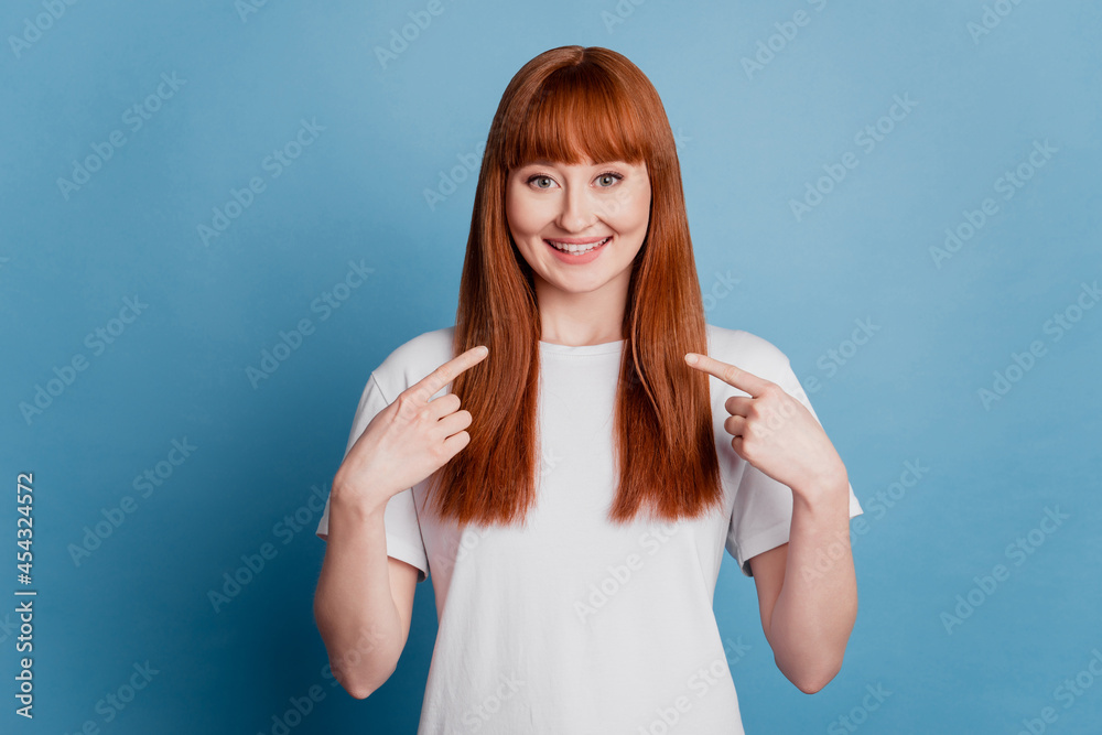 Portrait of girl pointing at herself isolated over blue background