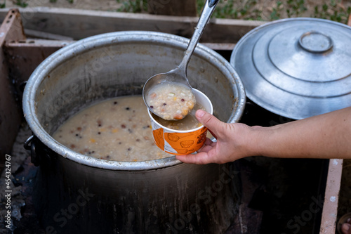 In the Islamic month, the woman who makes ashura in the cauldron fills the plates. Sharing and offering in Islamic culture.