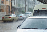 A heavy rain falling on a cars parking in front of a house in rainy day.