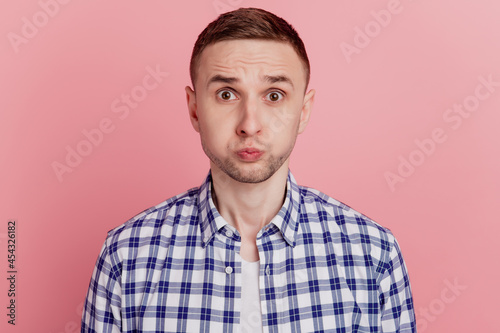 Portrait of young crazy man staring hold breath wear checkered shirt isolated on pink color background