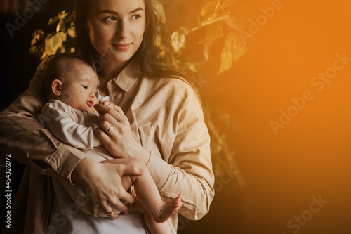 Young mother holding her newborn child. mother's care baby. Woman and new born girl relax. The concept of a newborn baby in a happy family