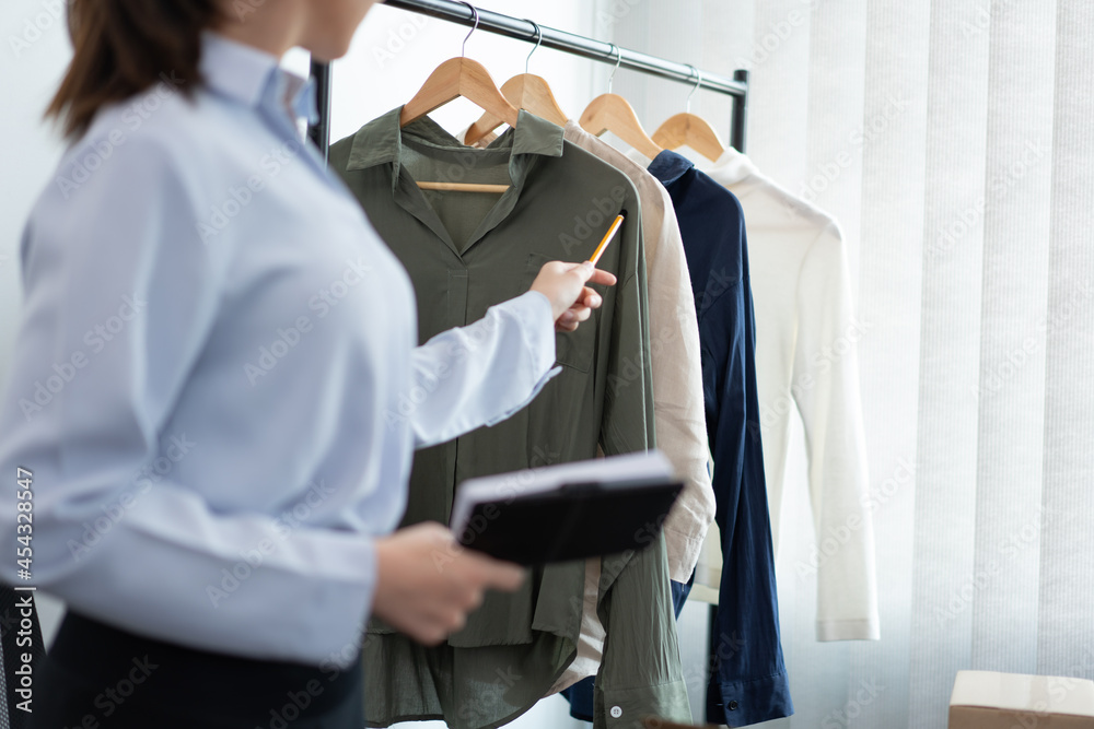 Live shopping concept a female seller broadcasting a livestream selling working long-sleeved shirts on social media Live shopping concept a female seller broadcasting a livestream selling working long-sleeved shirts on social media