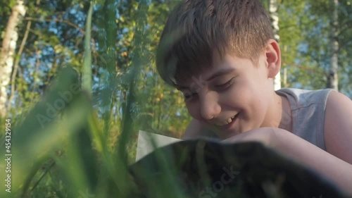 Children reading book on summer nature