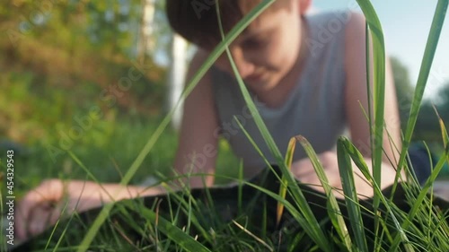 Boy reading book on summer nature