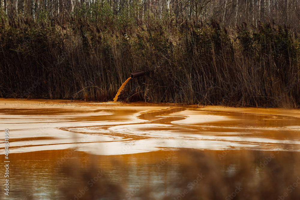Foto de the pipe discharges waste into the water. contamination of the