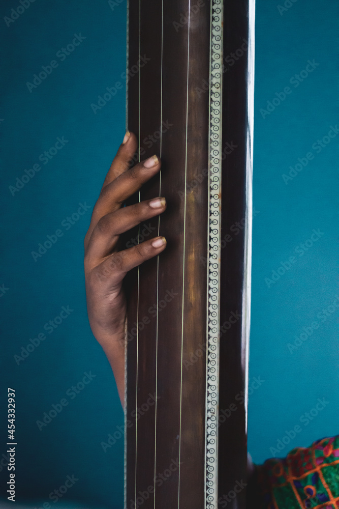 Middleaged Indian woman holding an Indian musical instrument tanpura or sitar Stock Photo