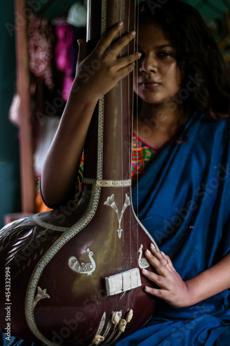 Fotografie Middle-aged Indian woman holding an Indian musical instrument tanpura or sitar