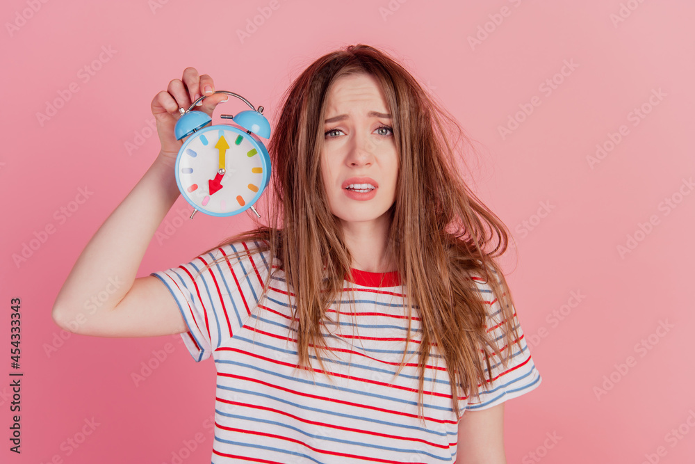 Portrait of charming crazy lady hold alarm clock frustrated face on pink background Portrait of charming crazy lady hold alarm clock frustrated face on pink background