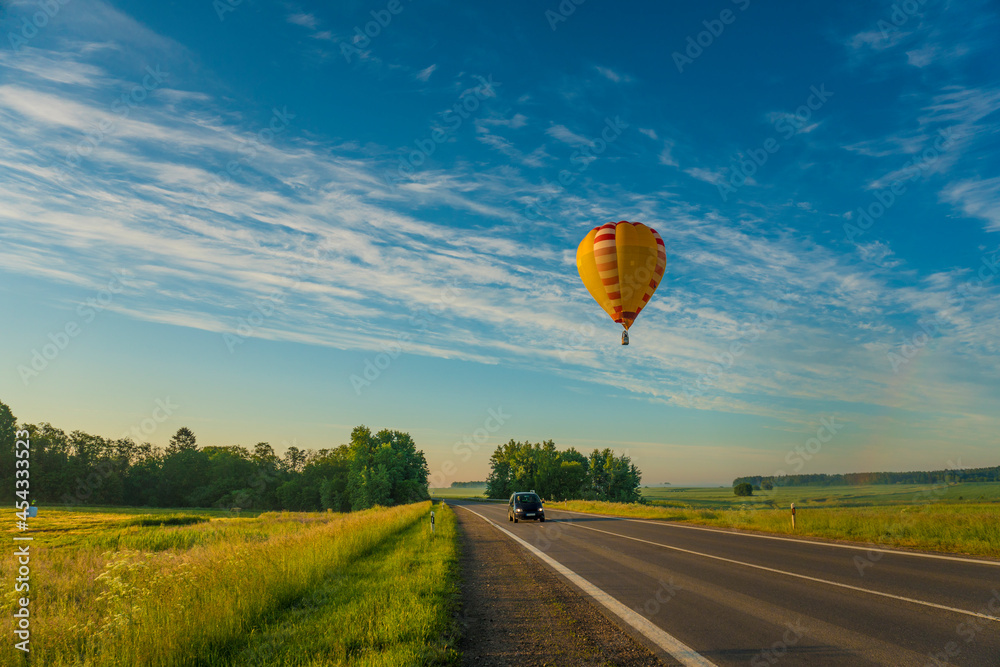Obraz premium hot air balloon flying over the road