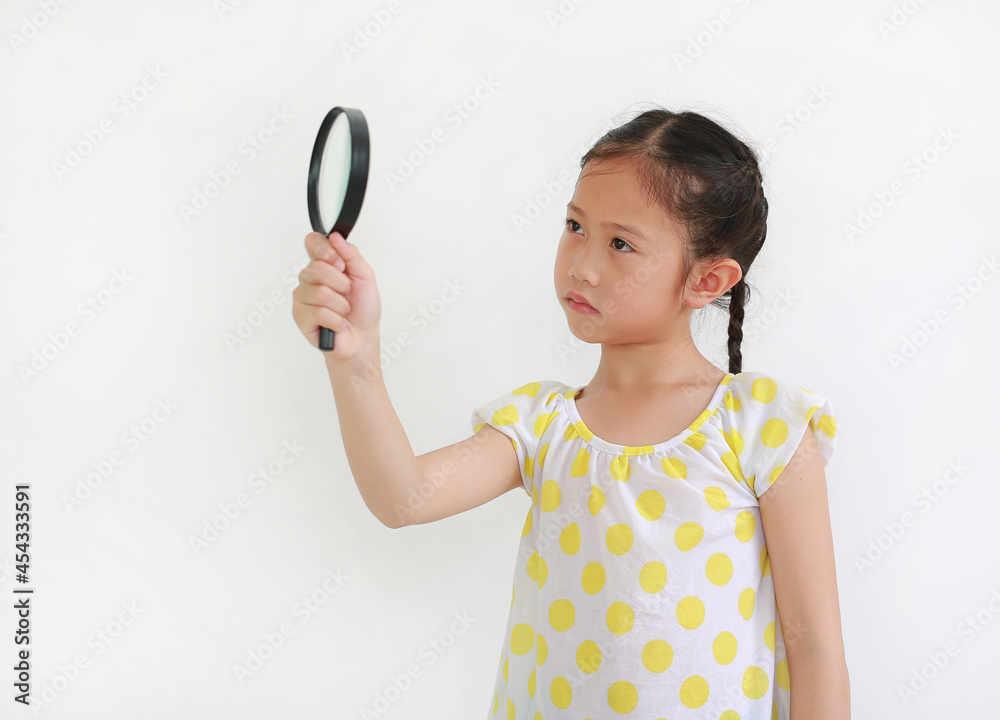 Surprised Asian Kid looking through a magnifying glass to beside on white background Surprised Asian Kid looking through a magnifying glass to beside on white background