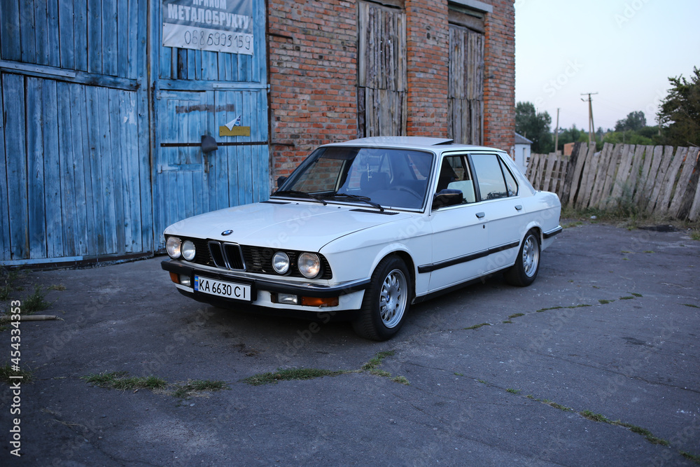  BMW E28 520i blanco retro con los faros encendidos.  Foto de stock |  adobestock