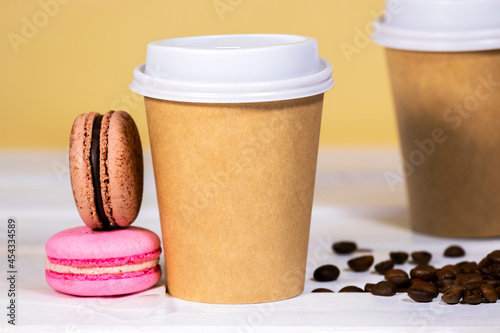 Coffee to go in paper eco cup with french macaroon on wooden and light orange background, Fast food, Copyspace, Caffeine Drink take away, Bean