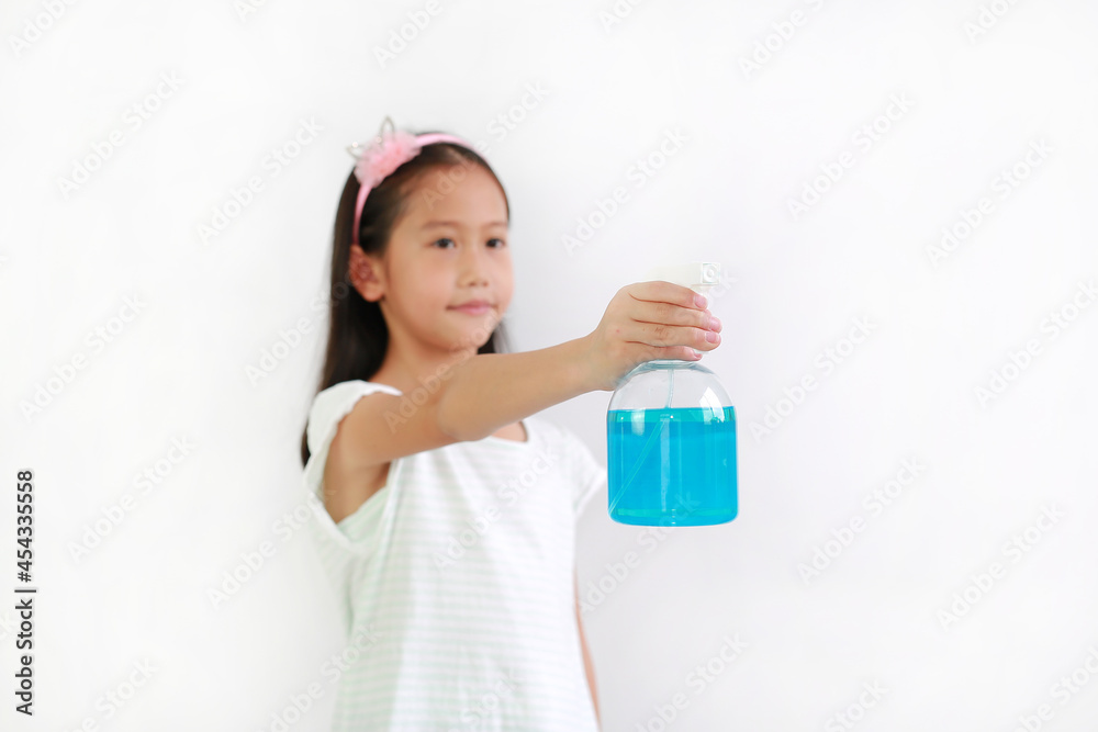 Asian girl kid using bottle spray alcohol liquid for against coronavirus pandemic outbreak on white background, antiseptic. Selective focus at kid hand and alcohol bottle Asian girl kid using bottle spray alcohol liquid for against coronavirus pandemic outbreak on white background, antiseptic. Selective focus at kid hand and alcohol bottle