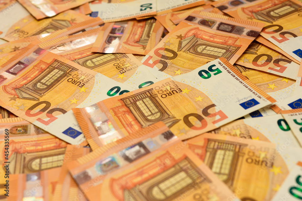Banknotes in the denomination of 50 euros are scattered randomly on the background, the texture of the European currency.